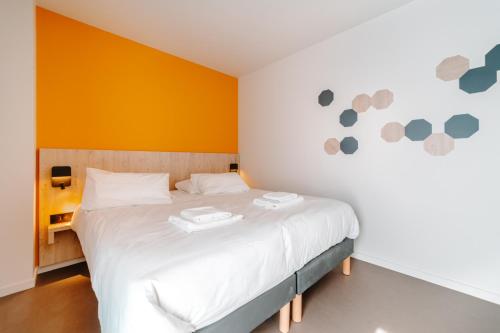 a bedroom with a bed with two plates on it at Beelodge Hotel Blois Centre in Blois