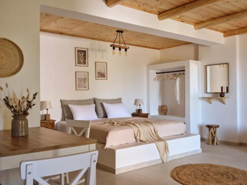 a bedroom with a bed and a table at Fairytale villas & suites marathias zakynthos in Marathias