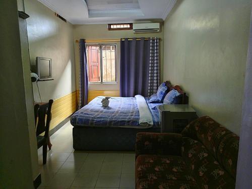ein kleines Schlafzimmer mit einem Bett und einem Fenster in der Unterkunft Big mountain inn in Moshi