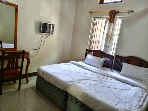 ein Schlafzimmer mit einem Bett und einem TV an der Wand in der Unterkunft Big mountain inn in Moshi