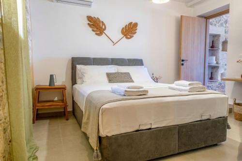 a bedroom with a large bed with two towels on it at Kefalas Luxury Villas Patitiri with Private Pool in Epáno Kefalás
