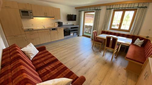 a living room with a couch and a table and a kitchen at Haus Brandhofer in Häselgehr