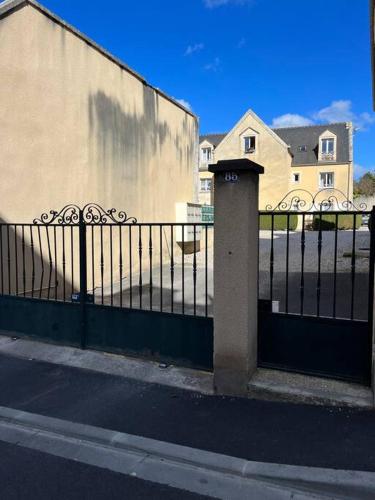 une clôture noire avec un poteau à côté d'un bâtiment dans l'établissement Appartement au centre ville de Bayeux, à Bayeux