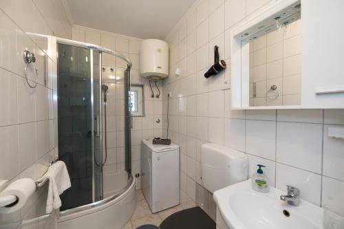 a bathroom with a shower and a toilet and a sink at Apartman Kesten in Lovran