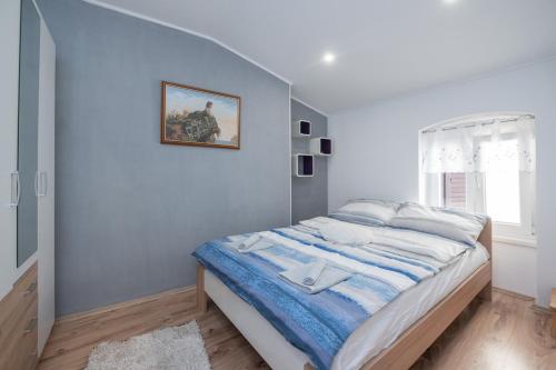 a bedroom with a bed with a picture on the wall at Apartman Kesten in Lovran