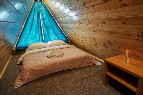 ein Schlafzimmer mit einem Bett in einer Holzhütte in der Unterkunft AMO in Gudauri