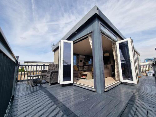 a small house with sliding glass doors on a deck at Thrillseeker - next to Fantasy Island, Ingoldmells, dog friendly in Skegness