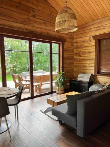 a living room with a couch and a table at Kaimukas - namelis prie ežero keturiems in Dvarčėnai