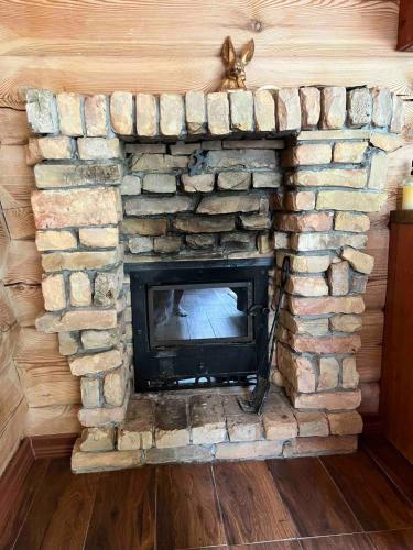 a stone fireplace in a living room at Kaimukas - namelis prie ežero keturiems in Dvarčėnai
