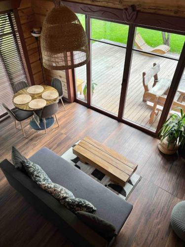 a living room with a couch and a table at Kaimukas - namelis prie ežero keturiems in Dvarčėnai
