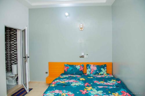 a bedroom with a bed with a blue comforter at Le Calypso in Cotonou