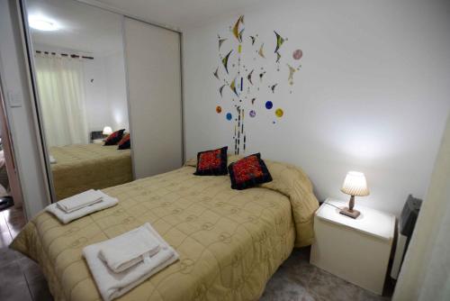 a small bedroom with two beds and a mirror at El Refugio in Ciudad Lujan de Cuyo