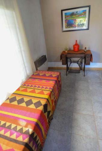 a bedroom with a bed and a table with a table at El Refugio in Ciudad Lujan de Cuyo