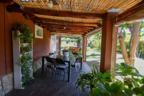 a patio with a table and chairs in a house at El Refugio in Ciudad Lujan de Cuyo