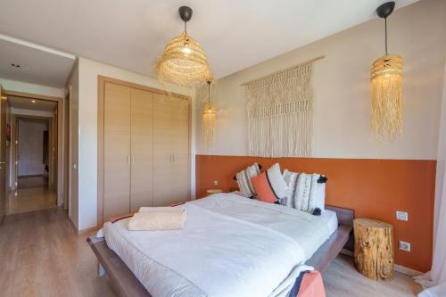 a bedroom with a large bed and two chandeliers at Stylish Bliss - Dream Apartment in Marrakesh