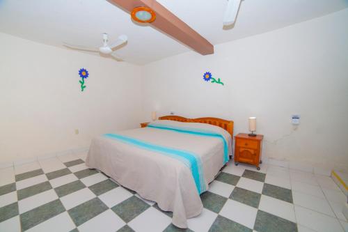 a bedroom with a bed and a checkered floor at Hotel Casa Rush in Puerto Ángel