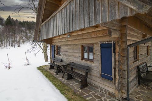 Cabaña de madera con banco y puerta azul en Chalet Kupljenik Near Bled Lake, en Bohinjska Bela