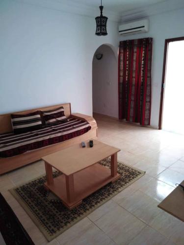 ein Wohnzimmer mit einem Bett und einem Couchtisch in der Unterkunft Appartement Hammamet in Hammamet