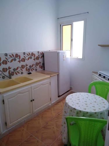 eine Küche mit einem Kühlschrank sowie einem Tisch und Stühlen in der Unterkunft Appartement Hammamet in Hammamet