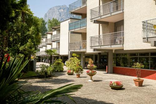 einen Innenhof mit Topfpflanzen vor einem Gebäude in der Unterkunft Riva Lago e Spiaggia Apartment 3 in Riva del Garda