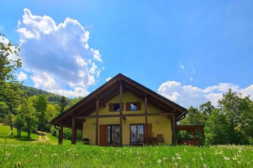 una pequeña casa en una colina con un campo verde en Forester's Hut With Whirlpool & Sauna - Happy Rentals, en Dol pri Hrastniku