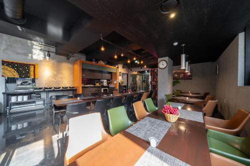 a restaurant with a table and chairs and a kitchen at Malu Hotel Suwon in Suwon