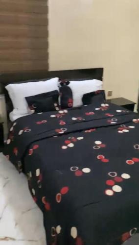 a bed with a black blanket with hearts on it at LA VIVA AIRBNB in Abuja