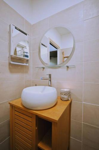 une salle de bain avec un lavabo blanc et un miroir dans l'établissement Appartement au calme rénové & climatisé en Plein centre du port, à La Grande Motte