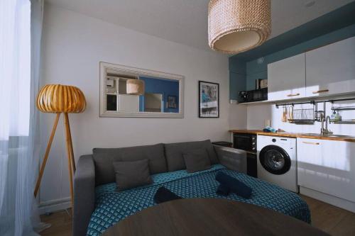 un salon avec un canapé et une cuisine dans l'établissement Appartement au calme rénové & climatisé en Plein centre du port, à La Grande Motte