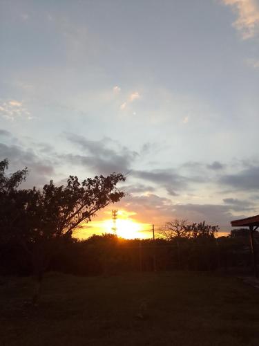 una puesta de sol con la puesta de sol en un campo en Habitacion cerca del aeropuerto, en Heredia