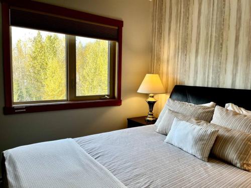 1 dormitorio con 1 cama grande y ventana en L202 - A Relaxed Vacation- 2BD+2BT, Heated Pool, Hot tubs, Gym, AC, Parkade, en Canmore