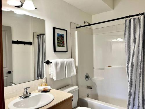y baño blanco con lavabo y ducha. en L202 - A Relaxed Vacation- 2BD+2BT, Heated Pool, Hot tubs, Gym, AC, Parkade, en Canmore