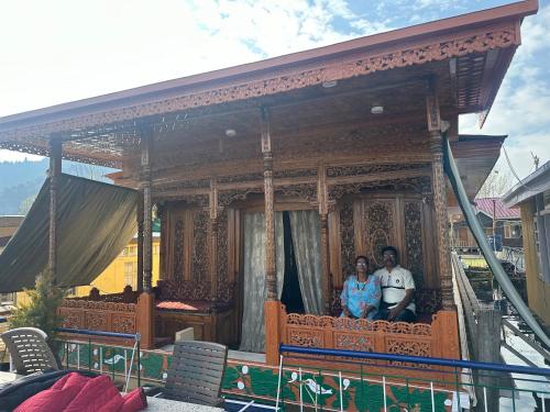 a man and woman standing on a balcony of a house at Movie land group of house boats in Srinagar