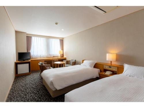 a hotel room with two beds and a television at Suikoyen Hotel - Vacation STAY 53766v in Kurume