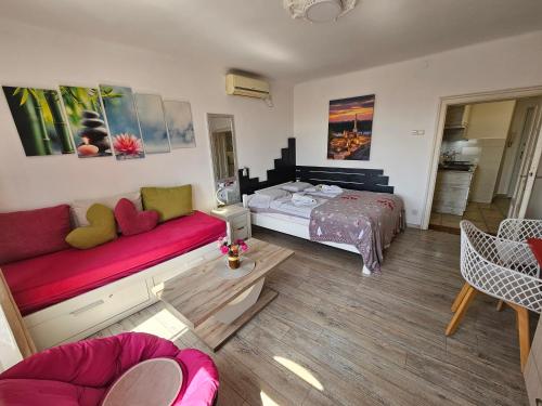 - un salon avec un lit et un canapé dans l'établissement Matea apartman, à Belgrade