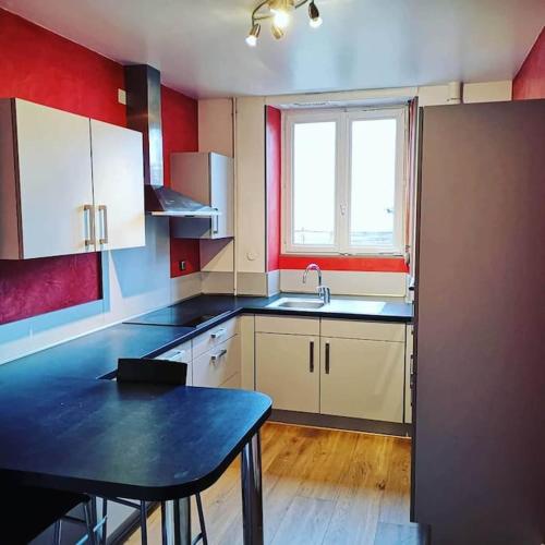 - une cuisine avec une table et un évier dans l'établissement Le Donjon de Mulhouse, à Mulhouse