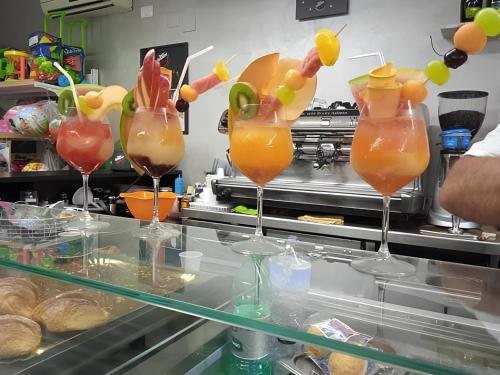 a row of cocktails in wine glasses on a counter at Ippocampo alba e tramonto in Ippocampo