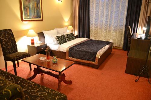 a hotel room with a bed and a table at Hotel JET SET Pale in Pale
