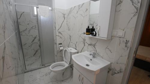 a white bathroom with a toilet and a sink at Seydikemer Yıldız hotel 