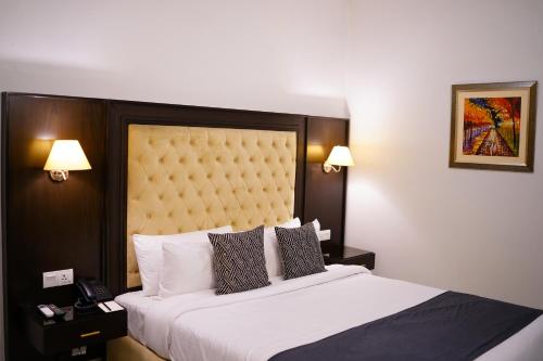 a bedroom with a large bed with a large headboard at Faletti’s Grand MM Alam Road in Lahore