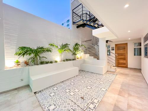 a white staircase in a house with plants at Stanza Hotel Monteria in Montería
