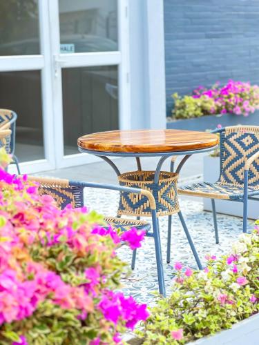 a wooden table and chairs and flowers on a patio at Stanza Hotel Monteria in Montería