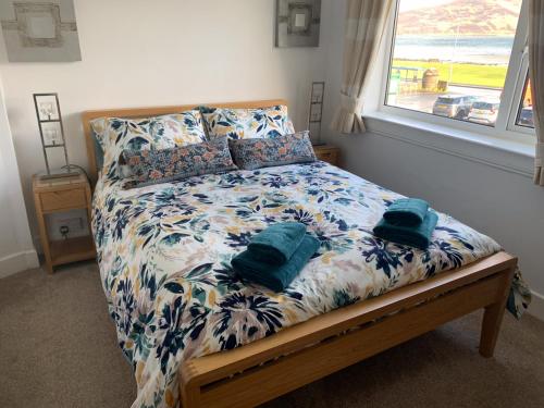 a bedroom with a bed with a floral bedspread at Eilean View in Lamlash