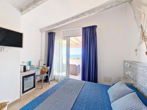 a bedroom with a blue bed and a window at L'onda marina in Castelsardo
