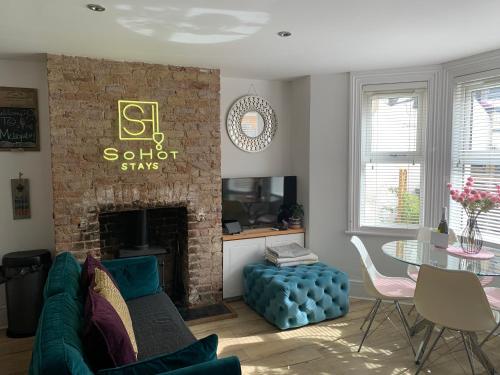 a living room with a couch and a fireplace at Stylish Coastal Retreat with Hot Tub & Log Burner in Margate in Margate