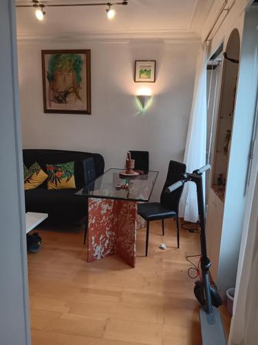 ein Wohnzimmer mit einem Glastisch und einem Sofa in der Unterkunft Apart calmo em paris jourdain in Paris
