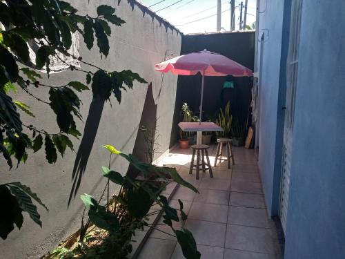 eine Terrasse mit einem Tisch und einem Sonnenschirm in der Unterkunft Casa da Ruthemar-Suite para 2 pessoas in São Sebastião