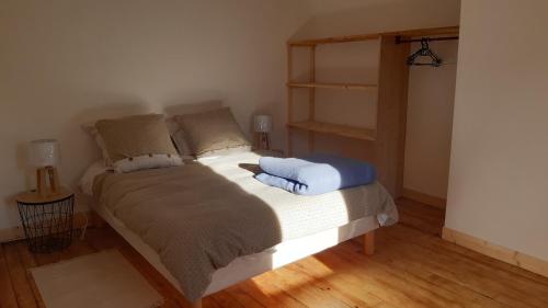 uma cama com duas almofadas num quarto em Maison de campagne em Issor