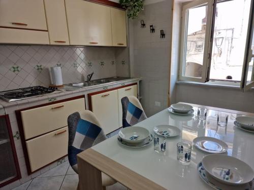eine Küche mit einem Tisch, Stühlen und einem Waschbecken in der Unterkunft Znc Holiday House in Cetara