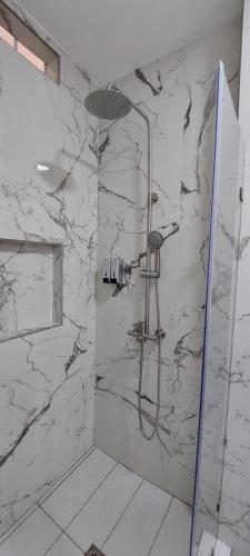 a bathroom with a shower with a stone wall at The Madevelyn in Atitlán in Panajachel